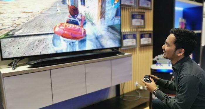 a Seorang Peraga bermain Games di Layar TV LED Besar.
